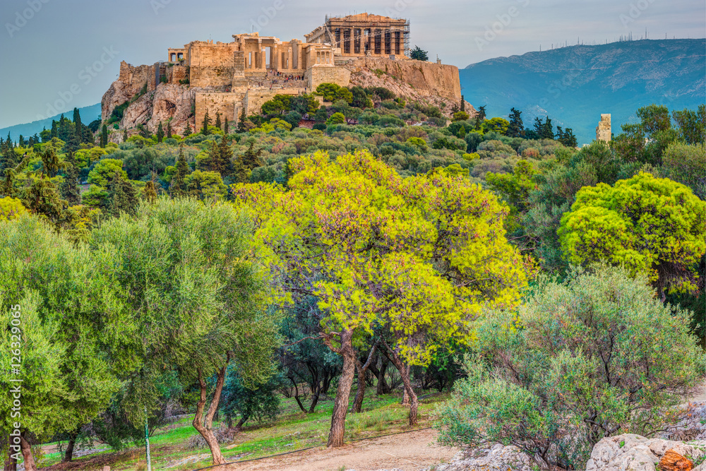 Parthenon and Herodium construction in Acropolis Hill in Athens, Greece. Beautiful landscape with green trees around ancient architecture.