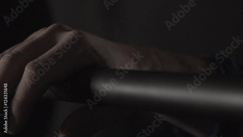 Hand grabbing or gripping metal weight bar in low light at Crossfit Gym During Workout in slow motion