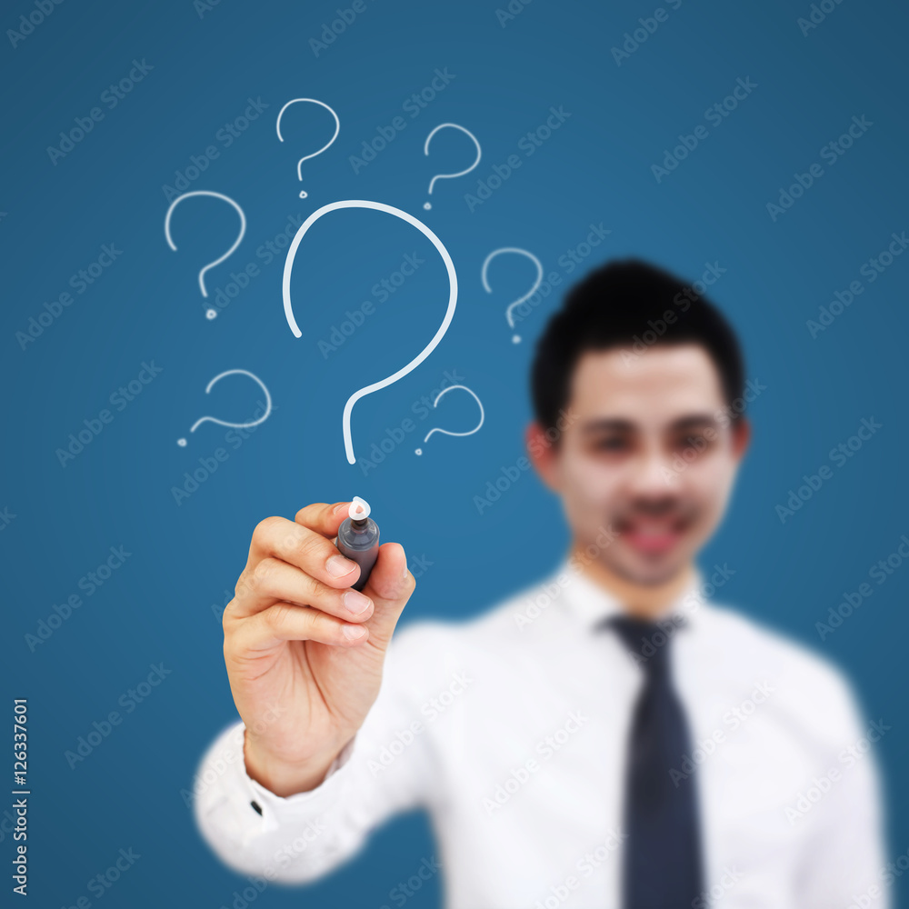 Businessman writing question marks. Businessman writing question marks.