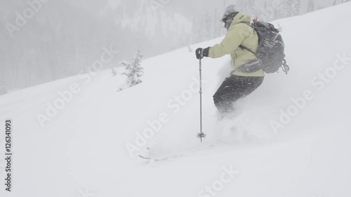 Skier skiing  in powder on winter snow during snowstorm  in slow motion