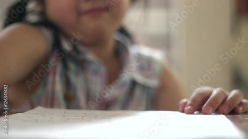 Little Asian child writing home work at home