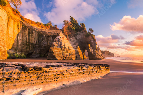 Sunset view of a rocky coast. Tongaporutu beach in Taranaki district, New Zealand, around the famous Three Sisters rock formation photo