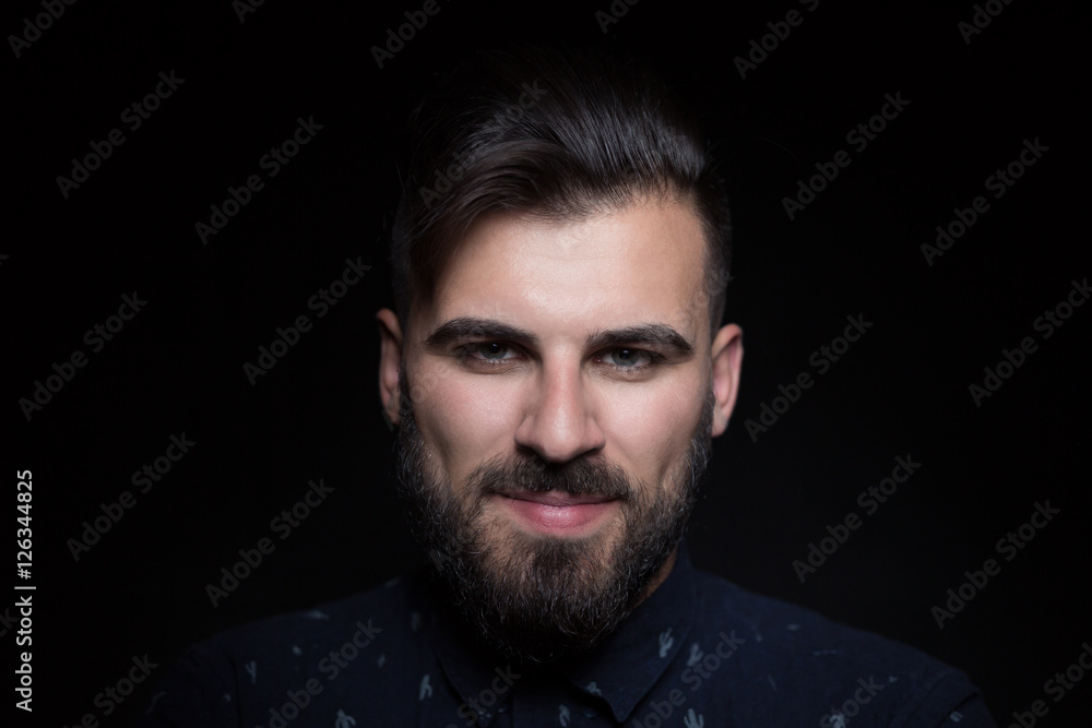 Portrait of handsome man wearing black shirt, black background,