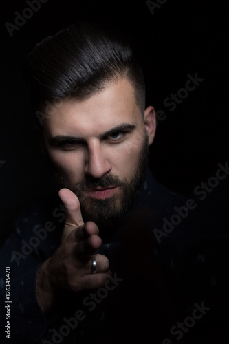 low key portrait of young handsome man in dark shirt  isolated o