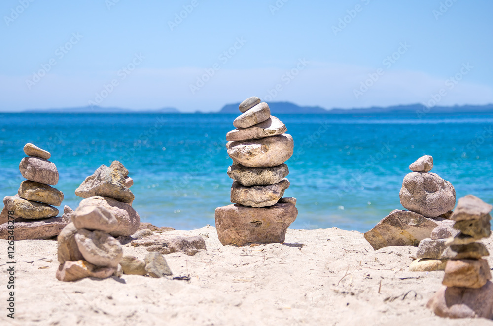 Stones stacked on the blue water beach
