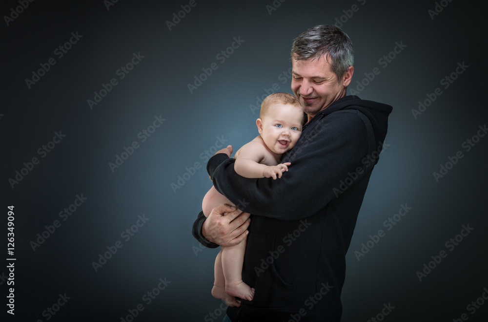 Obraz premium father holding a baby on a dark background