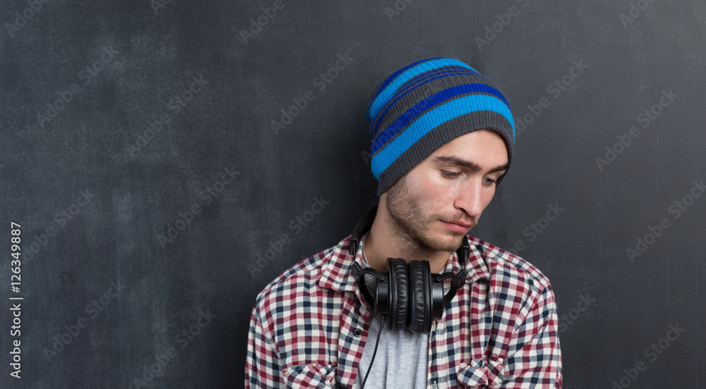 Fototapeta premium Handsome DJ posing in studio on dark background with headphones