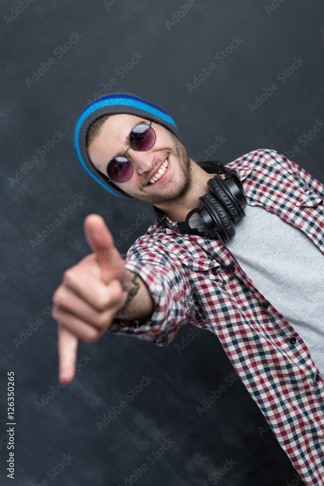 Carefree music lover. Joyful young man in headphones smiling aga Carefree music lover. Joyful young man in headphones smiling aga