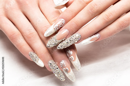 Beautifil wedding manicure for the bride in gentle tones with rhinestone. Nail Design. Close-up.