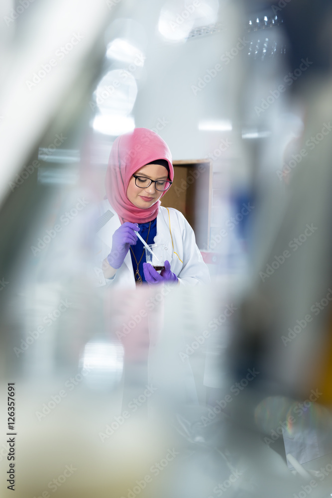 muslim lab worker with hijab or researcher doing an analysis in muslim lab worker with hijab or researcher doing an analysis in
