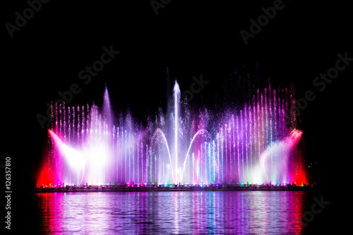 Beautiful fountain dancing show with reflection on water at night.