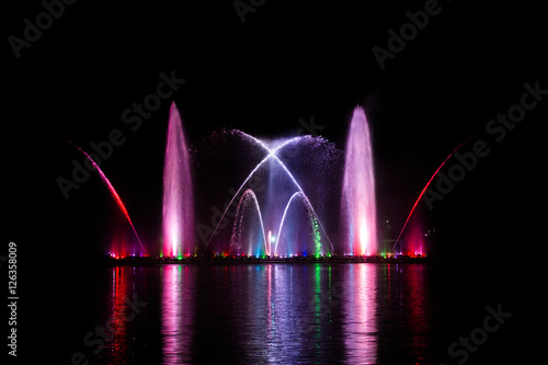 Beautiful fountain dancing show with reflection on water at night.
