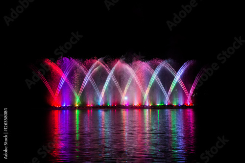 Beautiful fountain dancing show with reflection on water at night.