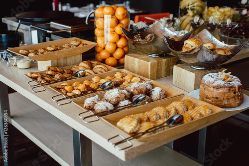 Assortment of fresh pastry on table in buffet photo
