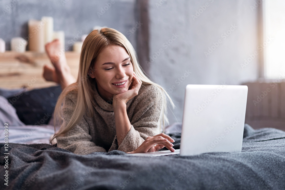 Fototapeta premium Pretty woman using laptop in bedroom