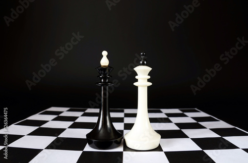 Two chess kings. Battle of equal competitors. Concept with chess pieces against black background