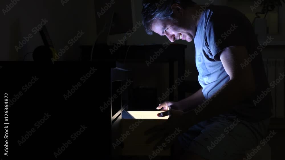 Handsome man opening illuminated drawer in dark room, profile view. Search, find, quest, and surprise concepts. 4K video Handsome man opening illuminated drawer in dark room, profile view. Search, find, quest, and surprise concepts. 4K video