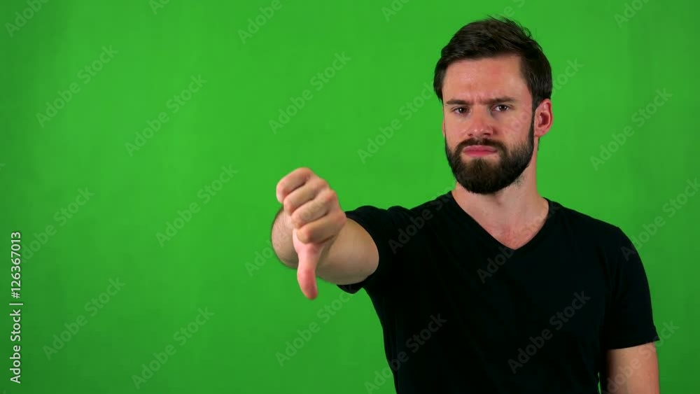 young handsome bearded man disagree (show thumb down) - green screen - studio young handsome bearded man disagree (show thumb down) - green screen - studio