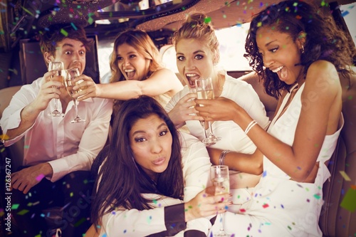 Composite image of happy friends drinking champagne