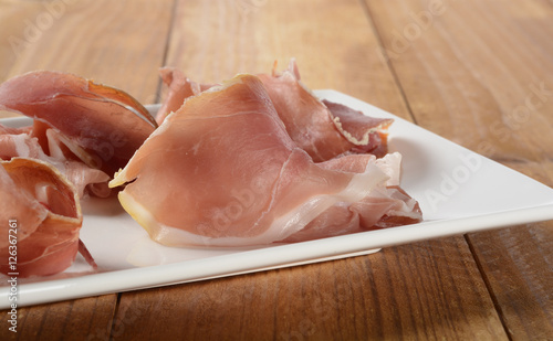 Jamón serrano en un plato en la mesa de madera