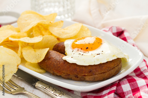 fried portuguese sausage alheira with egg and potato chips