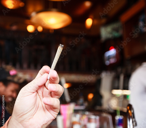 Man smoking marijuana cigarette in coffee shop in Amsterdam, Netherlands  