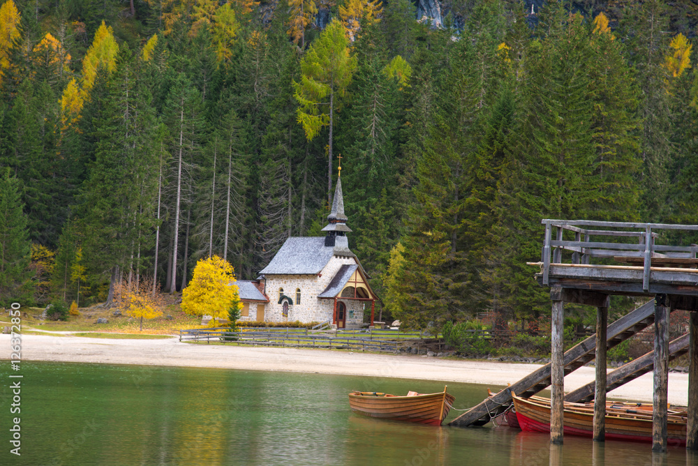 A beautiful autumn picture of the church near the lake on Fanes-