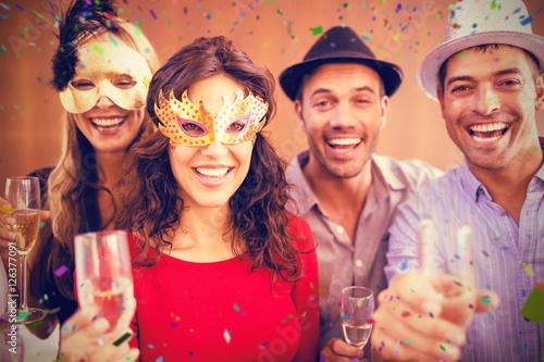 Composite image of portrait of friends holding champagne glasses