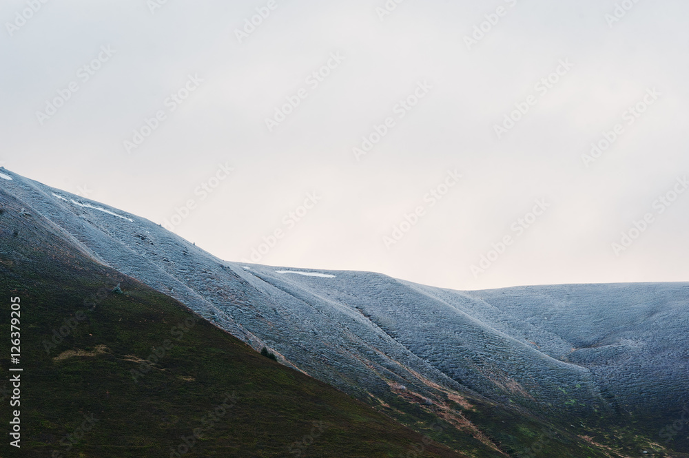 Snow-covered mountain top with trees at Carpathian mountains on