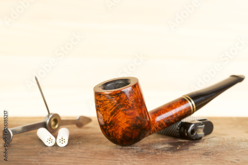 Smoking pipe on a wooden table. Aroma. Copy space