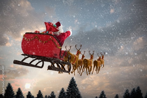 Obraz na plátně Composite image of santa claus riding on sleigh with gift box