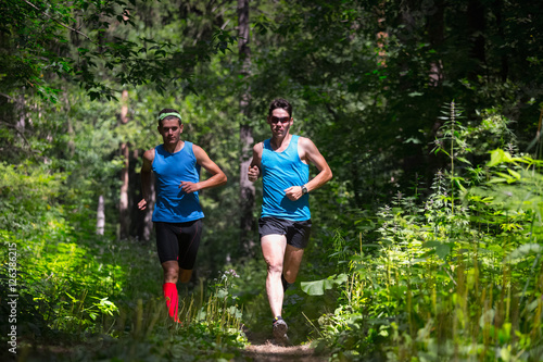 Trail running athletes moving through the forest
