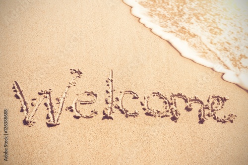 Welcome written on sand