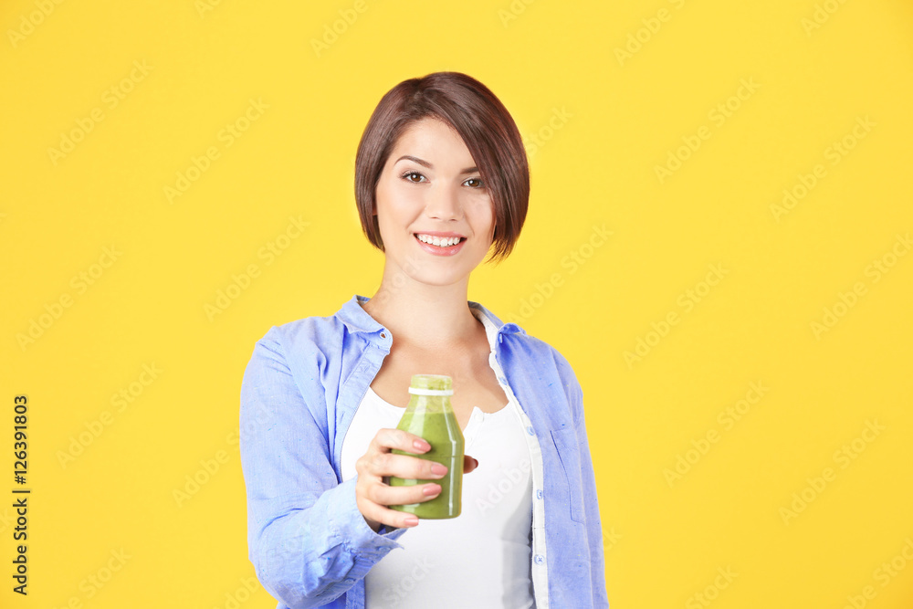 Young beautiful woman with green smoothie, on yellow background Young beautiful woman with green smoothie, on yellow background