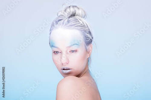 Model in creative image with silver blue artistic make-up