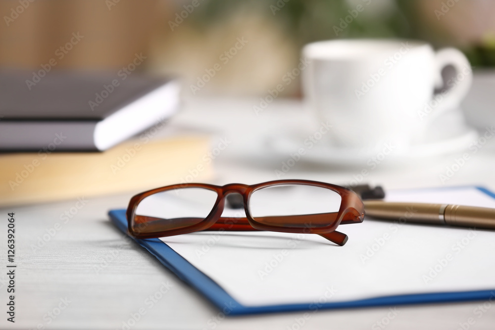Close up view of glasses on clipboard. Healthy eyes concept Close up view of glasses on clipboard. Healthy eyes concept