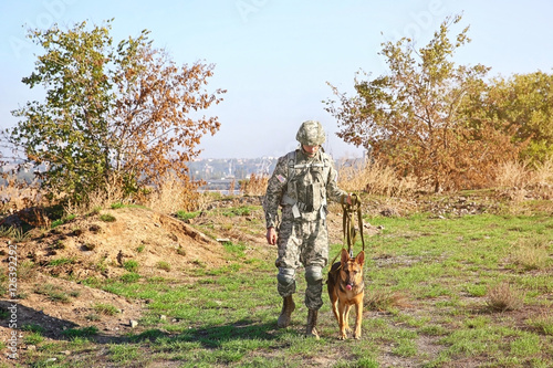 Soldier with german shepherd dog at military firing range