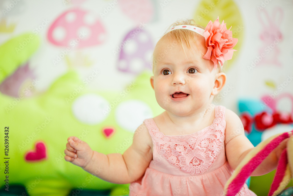 The baby sits on the bed in room The baby sits on the bed in room