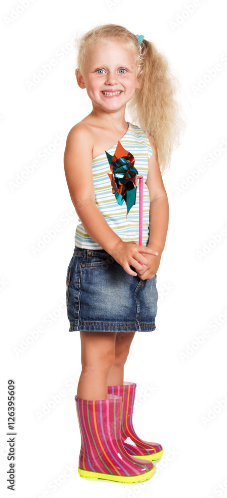 Cheerful little girl in rubber boots holding plastic windmill isolated. Cheerful little girl in rubber boots holding plastic windmill isolated.