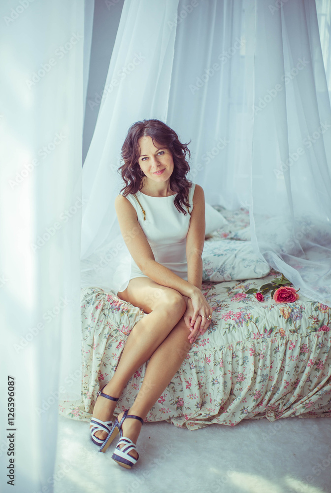 Fototapeta premium beautiful and gentle young woman sits on bed