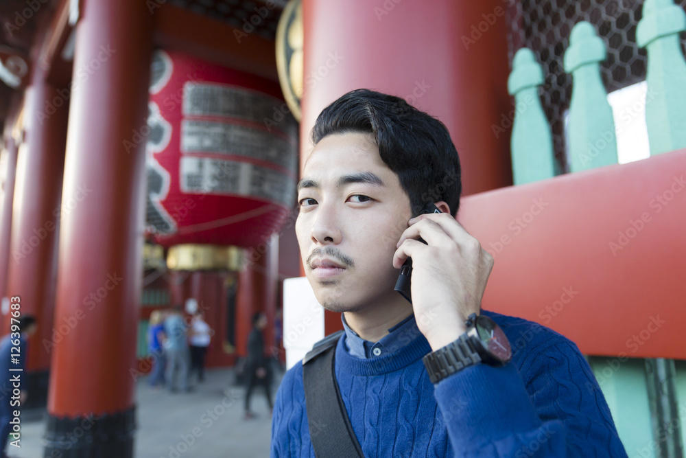 スマホ 男性 話す 若い カメラ目線 笑顔 秋 冬服 浅草 浅草寺 東京観光 Stock 写真 Adobe Stock