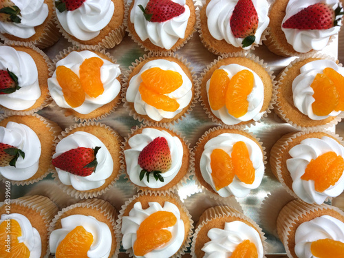 Cupcake with whipped cream with strawberry and orange topping