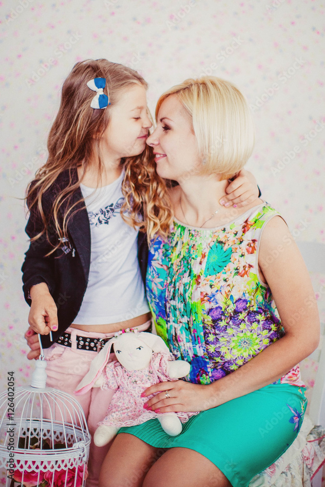 little cute girl and her mother sitting on chair little cute girl and her mother sitting on chair