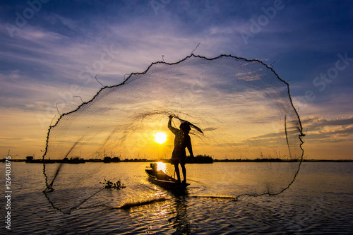 fishermen throwing net fishing in lake on morning sunrise