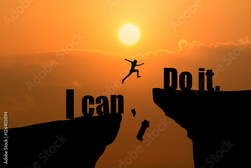 Man jumping on I can do it or I can't do it text over cliff on sunset background