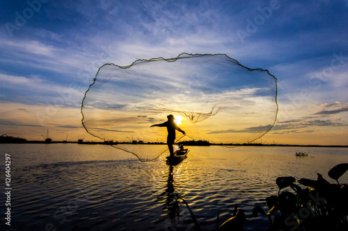 fishermen throwing net fishing in lake on morning sunrise