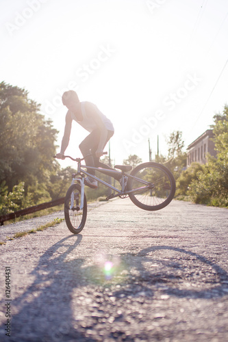 The boy ride on bike at sunrise background
