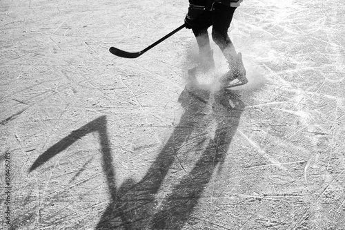hockey player on the ice on sunset - black and white photo