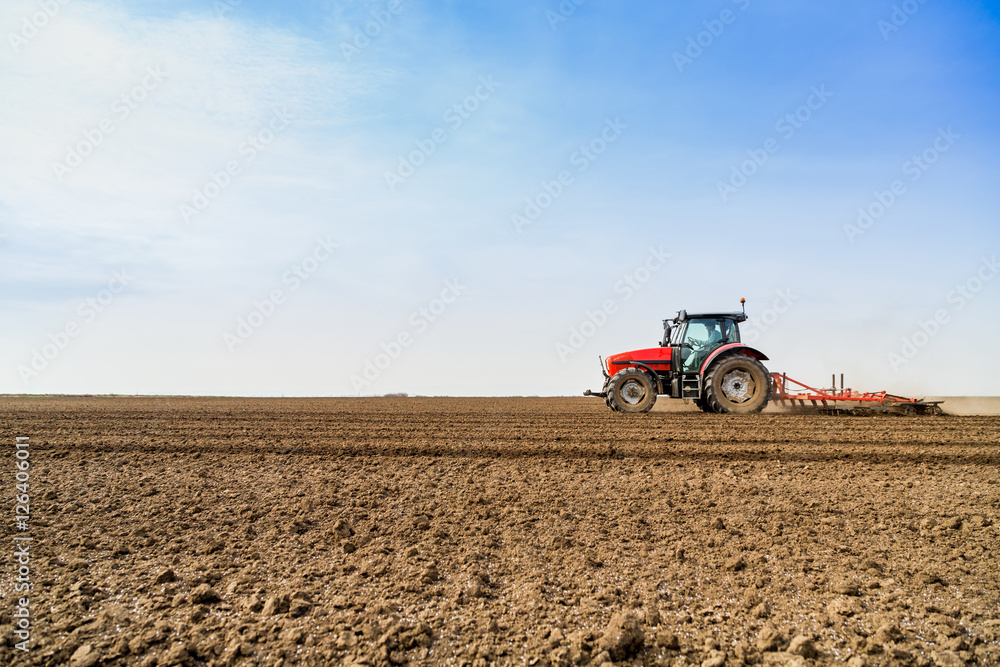 Farmer in tractor preparing land with seedbed cultivator