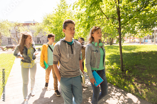 group of happy teenage students walking outdoors